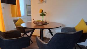 a table with chairs and a vase with a flower at Lemon Garden Villapark in Bükfürdő