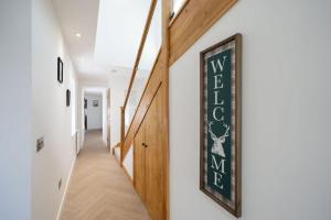 a hallway of a house with a sign on the wall at Easter Cottage -4 Bed Converted Barn Cottage in Turriff
