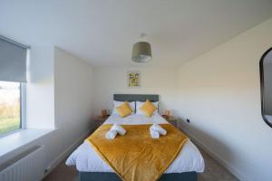 a bedroom with a bed with yellow pillows at Easter Cottage -4 Bed Converted Barn Cottage in Turriff