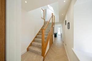 a staircase in a home with white walls and wooden railings at Easter Cottage -4 Bed Converted Barn Cottage in Turriff