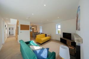 a living room with a green couch and a yellow chair at Easter Cottage -4 Bed Converted Barn Cottage in Turriff +28 photos