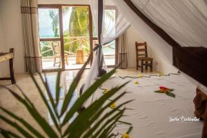 ein Zimmer mit einem Bett mit einer Blume darauf in der Unterkunft Moonshine Uroa Boutique Hotel in Uroa