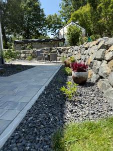 a stone retaining wall and a walkway with flowers at Ferienwohnung am Blender in Wiggensbach