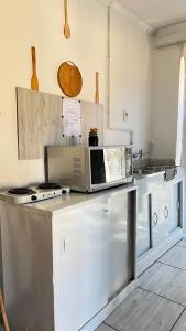 a kitchen with a microwave on top of a counter at KaChichima in Springs
