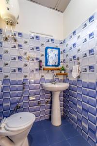 a blue tiled bathroom with a toilet and a sink at The Hood Bir Billing in Bīr +102 photos