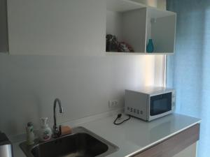 a kitchen with a sink and a microwave on a counter at Baan Tew Lom Cha-am (339/448) in Cha Am