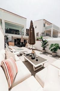 a patio with white couches and a umbrella at Unique Villa Scandinavia Marbella in Marbella +156 photos