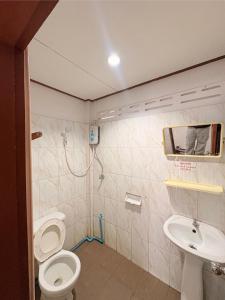 a bathroom with a toilet and a sink at ฤทัยลอดจ์ in Ban Tao Than