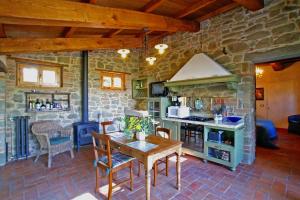 a kitchen with a table and a stone wall at Villa Ceppeto in Monte San Savino