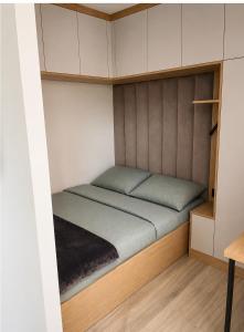 a bed in a small room with white cabinets at Kaszmirowy Apartament in Wałcz