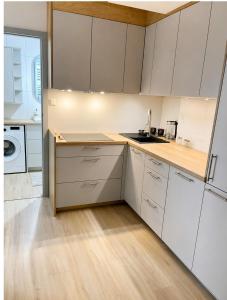 a kitchen with white cabinets and a wooden floor at Kaszmirowy Apartament in Wałcz +9 photos