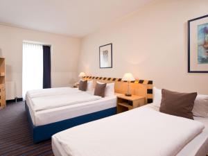 ein Hotelzimmer mit 2 Betten und einem Fenster in der Unterkunft ACHAT Hotel Dresden Elbufer in Dresden