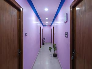 a hallway with pink and purple walls and a potted plant at Hotel Jagdamba Residency in Chupra