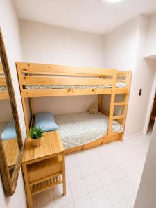 a room with two bunk beds and a table at Casa Soleá- a dos min de la playa in Castell de Ferro