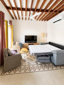 a living room with a bed and a couch at Casa Soleá- a dos min de la playa in Castell de Ferro