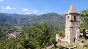 an old building on a hill with mountains in the background at Rifugio lo Schioppo in Morino