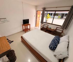 a bedroom with a large bed and a window at ฤทัยลอดจ์ in Ban Tao Than