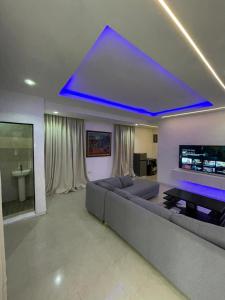 a living room with a large couch and a blue ceiling at Cyril O Apartment in Lagos