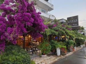 a street with purple flowers and plants in front of a building at Doruk Hotel in Tıraça