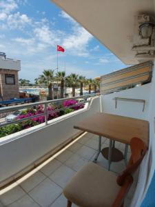 a table and a chair on a balcony with a flag at Doruk Hotel in Tıraça