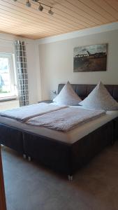 a large bed in a bedroom with a wooden ceiling at Ferienwohnung Römerweinhof in Neumagen-Dhron