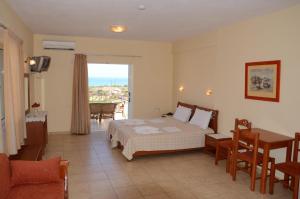 a bedroom with a bed and a table and a window at Elafonisos Diamond Resort in Elafonisos