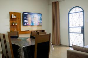 a living room with a dining table and a tv at Casa Alegria até 9 pessoas, Piscina, Churrasqueira, Empresas e Grupos in Montes Claros