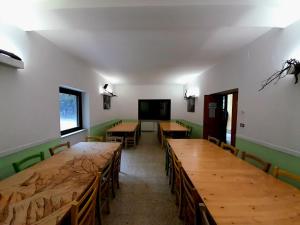a room with wooden tables and chairs and a flat screen tv at Rifugio lo Schioppo in Morino +15 photos