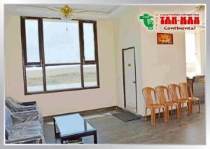a living room with chairs and a table and a window at Hotel Tanman Continental, Rajgir in Rājgīr Kund