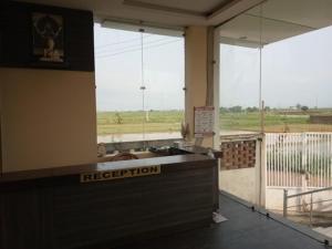 a room with a reception desk with a view of a field at Hotel Tanman Continental, Rajgir in Rājgīr Kund