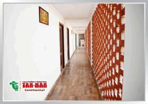 a hallway with a red brick wall and a hallway sidx sidx sidx at Hotel Tanman Continental, Rajgir in Rājgīr Kund +1 photo
