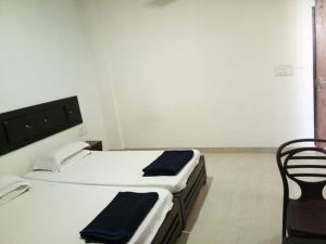 a white room with a bed and a chair at Hotel Tanman Continental, Rajgir in Rājgīr Kund