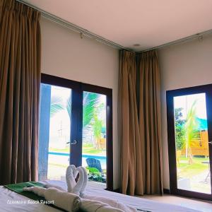 a bedroom with a bed and a large window at Oceanaire Beach Resort ELYU in Bacnotan