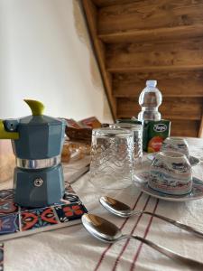 a table with a coffee maker and spoons on it at Piazza San Giorgio B&B in Serrano