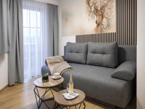 a living room with a couch and two tables at Hotel zur Linde - Bayerischer Wald - aktivCard mit 154 kostenfreien Leistungen - kostenloser Parkplatz in Lohberg +34 photos