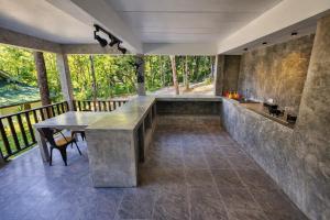 a room with a table and a bench on a balcony at Flower Power Farm Village in Ko Phayam