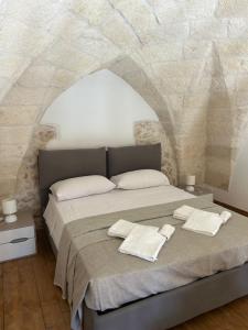 a bedroom with a large bed in a stone wall at Piazza San Giorgio B&B in Serrano