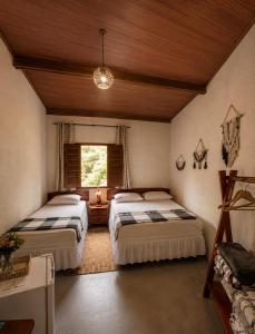 a bedroom with two beds and a window at Reserva do Bosque Hospedaria e Natureza in Ibicoara