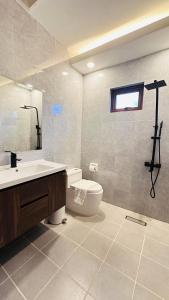 a bathroom with a sink and a toilet and a window at Oceanaire Beach Resort ELYU in Bacnotan +46 photos