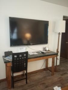 a desk with a large flat screen tv on a wall at Simple Stay in Youngstown