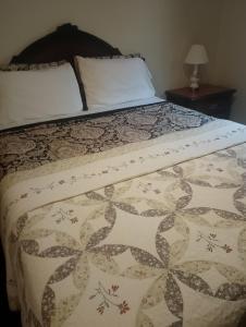 a bed with a comforter on top of it at Simple Stay in Youngstown +37 photos