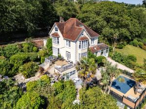 an aerial view of a large white house with a swimming pool at The Charterhouse in Torquay