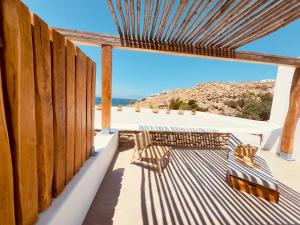 a patio with two benches and a view of the ocean at Aelia Mykonos in Ornos