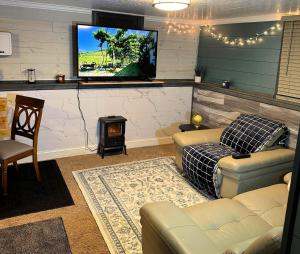 a living room with a couch and a flat screen tv at The Hideout in Moorhead