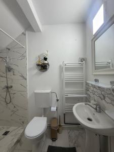 a white bathroom with a toilet and a sink at Vila MaeStar in Curtea de Argeş +37 photos