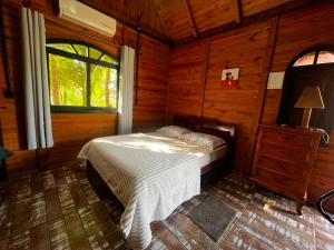 a bedroom with a bed in a wooden cabin at Chalé Alpino Apiúna in Apiúna