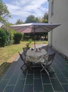a table with an umbrella on a patio at Les 2 Chênes in Saumur +4 photos