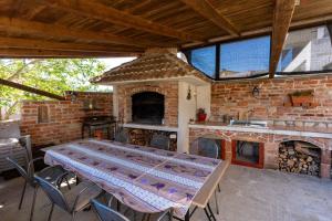 a patio with a table and a brick fireplace at Marin in Lopar +19 photos