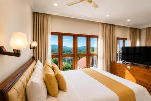 a bedroom with a large bed with a large window at Astralis Resort Coorg in Madikeri
