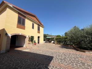 a house with a brick driveway next to a building at B&B Residenza Gigina in Sezze